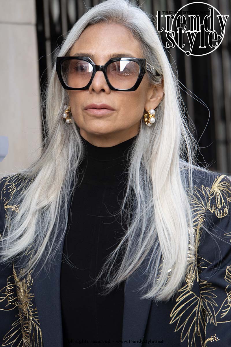 Vrouw met lang natuurlijk grijs haar en een stijlvolle outfit tijdens Paris Fashion Week. Foto Charlotte Mesman